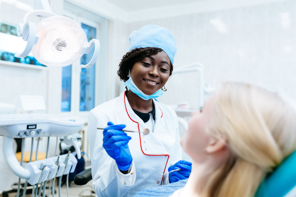 African american female dentist treating patient at clinic