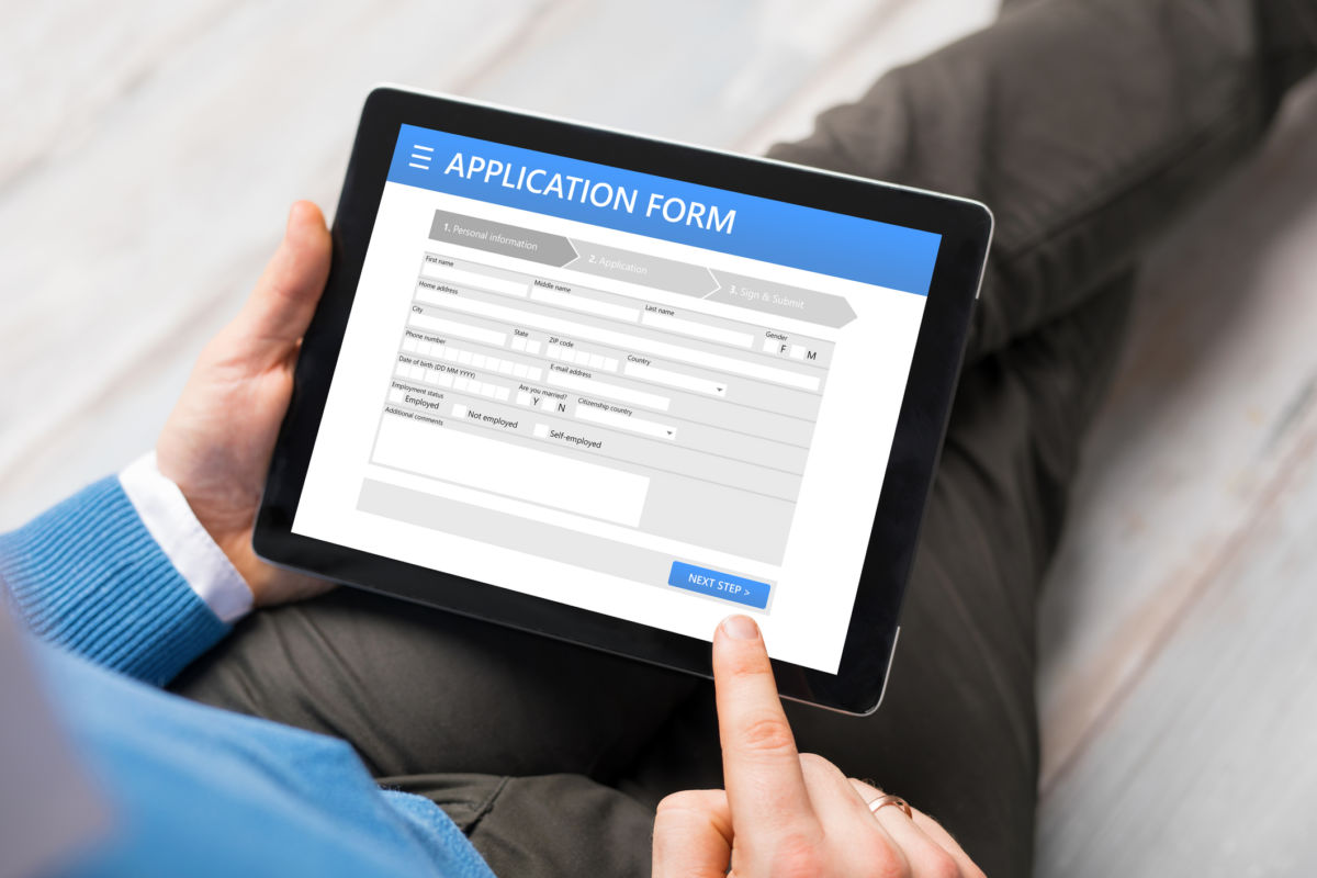 Sample application form on tablet computer, man using tablet